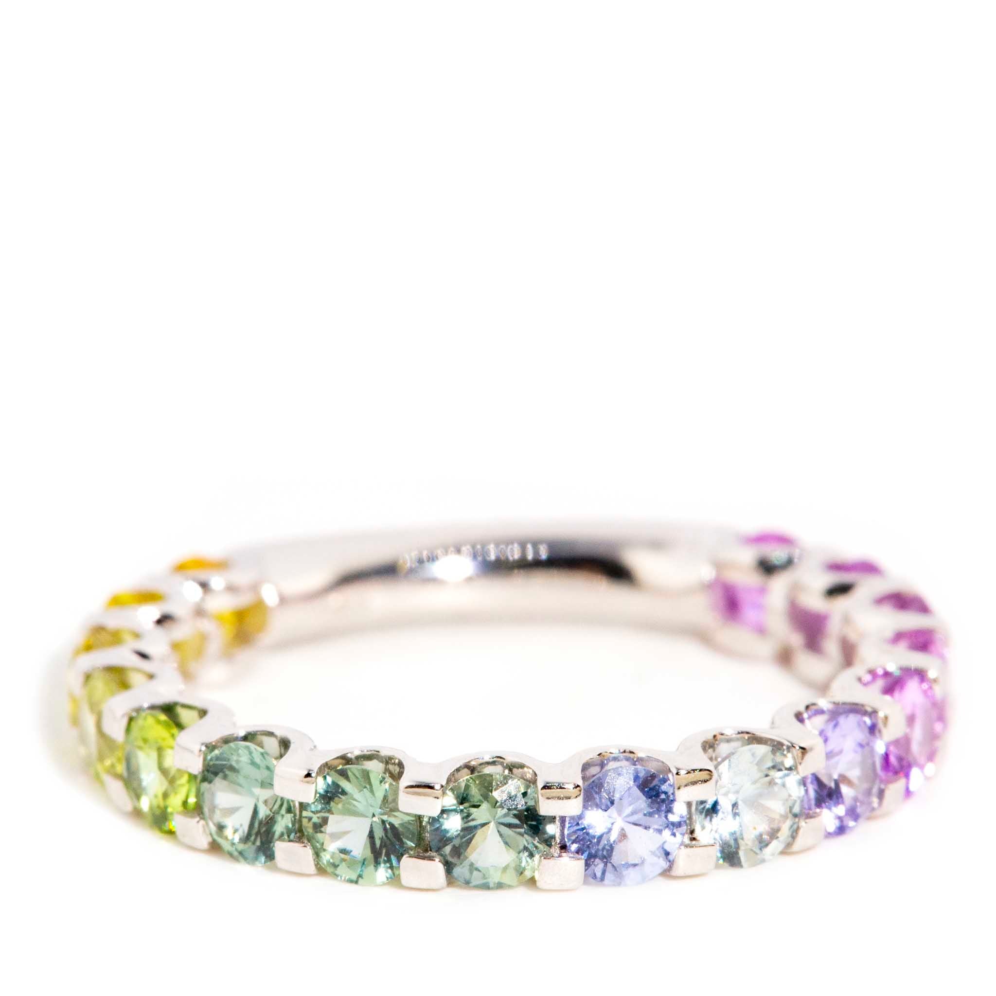 AI ALT: 18ct gold ring with ombre Ceylon sapphires in blue, pink, purple, green, and yellow hues, set in a round band.
